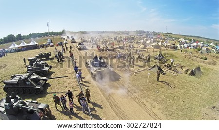 RUSSIA, NELIDOVO -?? JUL 12, 2014: Tanks ride near military camp with many people during reconstruction Battlefield at Second World War. Aerial view (Photo with noise from action camera)