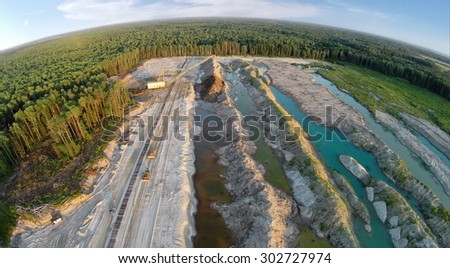 RUSSIA, VOSKRESENSK - JUL 1, 2014: Excavator is working near forest and old railway. Aerial view. (Photo with noise from action camera)