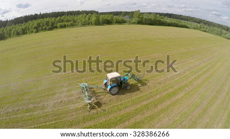 Tractor collect hay on field at summer sunny day. Aerial view videoframe