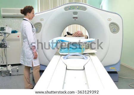 Radiologic technician and Patient being scanned and diagnosed on CT (computed tomography) scanner in hospital
