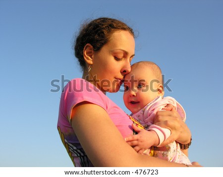 faces mother with baby on sunset  touch nose