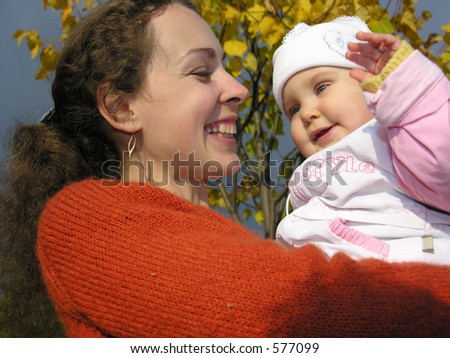 faces mother with baby on autumn leaves