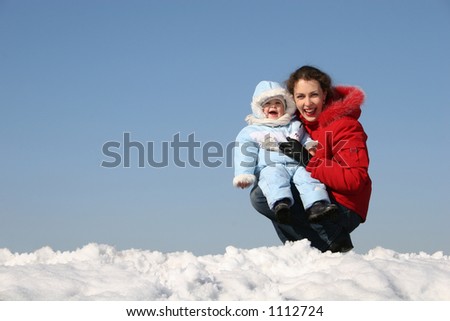 smile mother sit with baby. winter