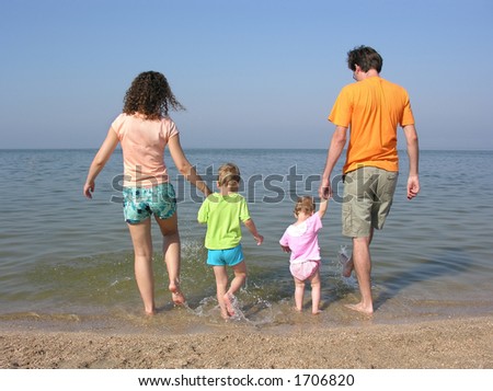 behind family of four on beach