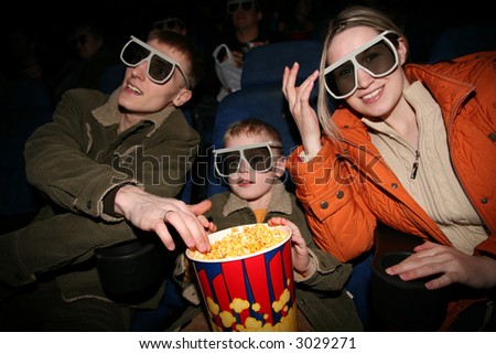 family in stereo cinema. focus on popcorn