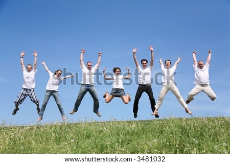 Seven friends in white T-shorts joyfully jump together