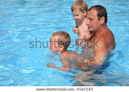 Grandfather with grandsons in pool