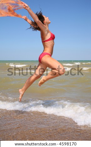 The woman jumps with a scarf.