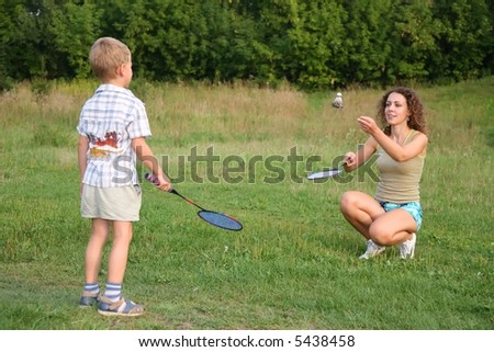 Mother plays with son in badminton