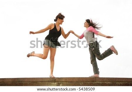 mother and daughter dance on the rock wall