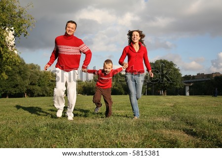 father and mother run, holding son for the hands
