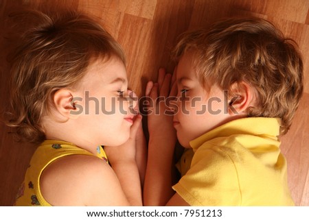 two children sleep on floor