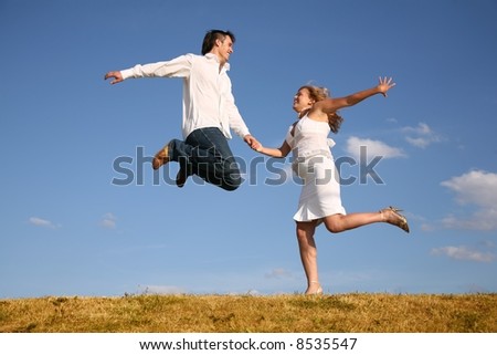 man jumps on meadow hold girl from hand