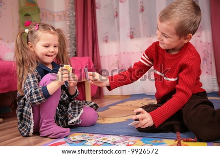 two children play cards in playroom
