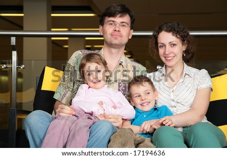 family sit on sofa in dark hall