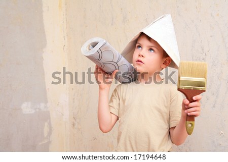 boy with brush and roll of wallpaper in papper hat