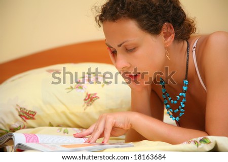 Young woman reads on bed