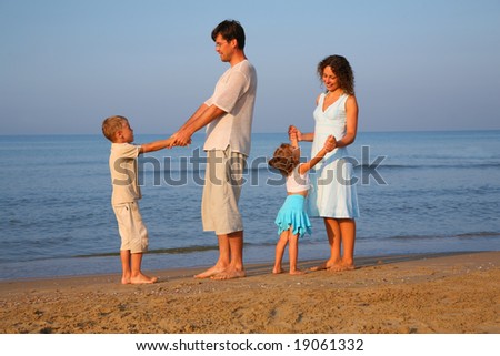 Parents with children standing  at edge of  sea