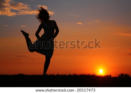 Silhouette of dancing woman on sunset