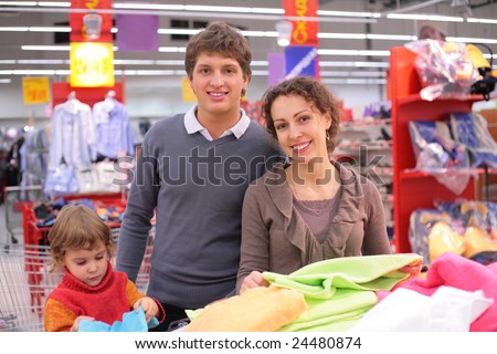 Family with little girl choose  fabric in shop