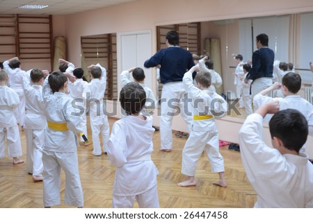 karate boys training in sport hall, focus on left boy in yellow belt