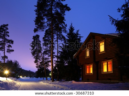 wooden house in winter wood in twilight