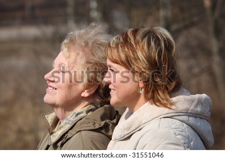 Smiling elderly woman and her daughter in profile