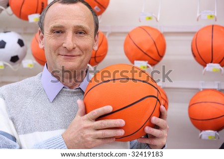elderly man in shop with volleyball ball in hands