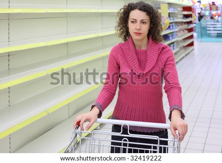 young woman with  cart in shop with empty shelves