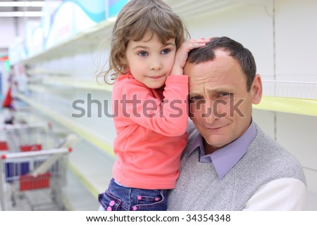 elderly man at empty shelves in  shop with child on hands