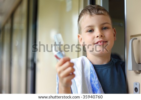 boy in wagon of train with tooth-paste and  brush
