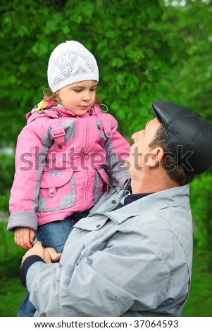 man lifts little girl
