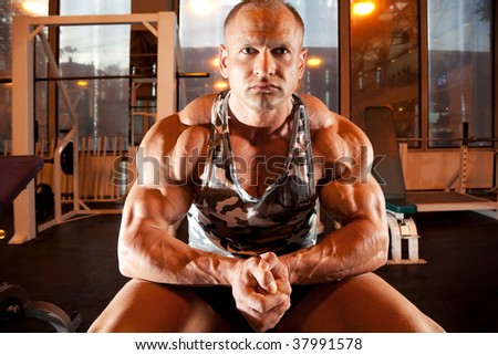 bodybuilder sits in training room