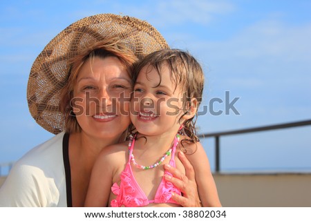 stock photo mature woman with little girl in swimsuit on veranda