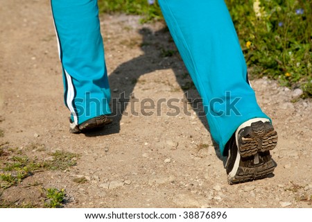 feet of young woman jogging in the country
