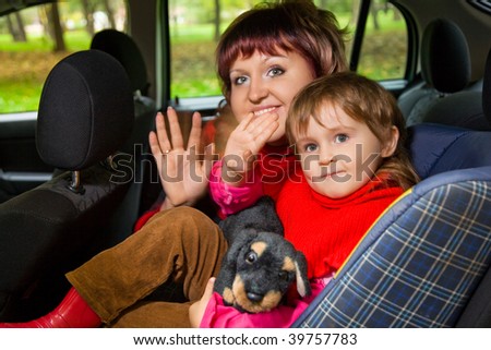 woman and  little girl  Greeting to wave hands in car in park