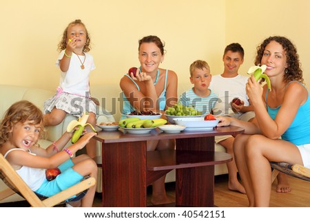 big happy family with children eats fruit in cozy room