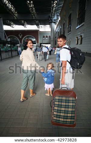 Happy family with little girl at railway station