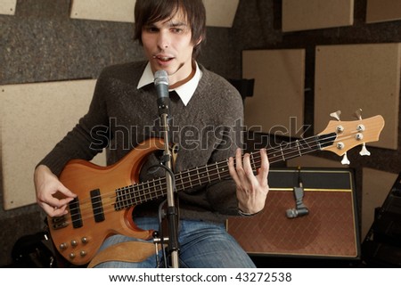 guitar player is playing and singing in studio. focus on guitar head