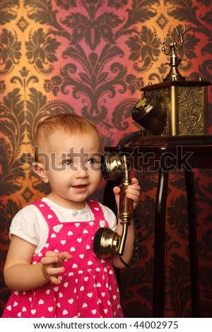 Little girl in red dress talking vintage phone. Interior in retro style. Vertical format.