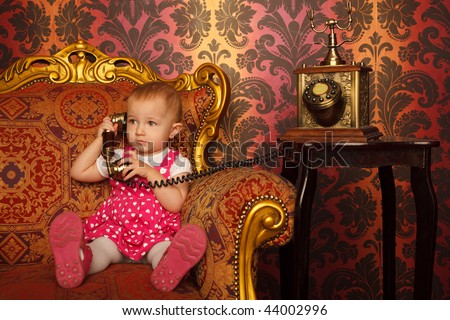 Little girl in red dress talking vintage phone. Interior in retro style. Horizontal format.