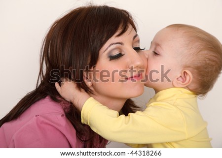 Little daughter kissing her mother. Close up. Horizontal format.