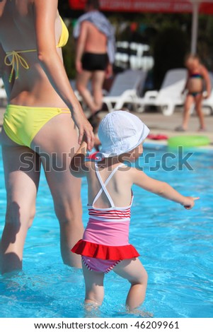 beautiful woman and little girl going on paddling pool in aquapark