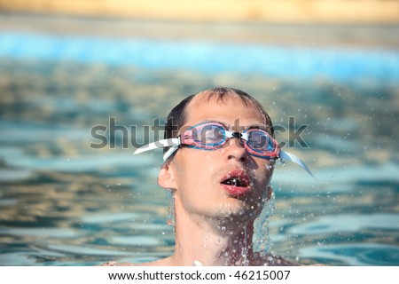 young man in waters sport goggles swimming in pool, Come up from water, taking breath