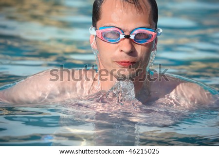 young man in waters sport goggles swimming in pool