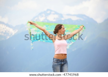 beautiful joyful woman with kerchief is looking away. mountains in background.