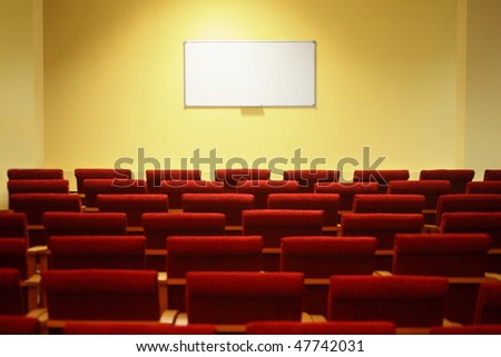 empty conference hall with screen. rows of a chairs. focus on a screen.