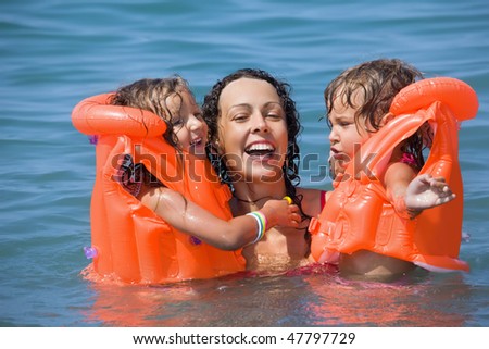stock photo two little girls bathing in lifejackets with young woman in 
