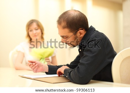 stock photo man in black shirt making sign on wedding documents 