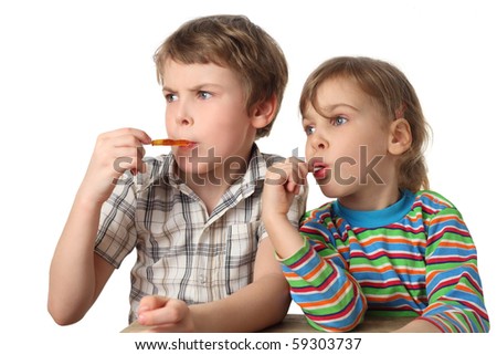 little boy and girl eating lollipops and looking at left side, half body, isolated on white